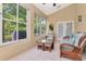 Cozy sunroom features tile flooring, many large windows, and casual wicker furniture at 1188 Royal Blvd, Palm Harbor, FL 34684