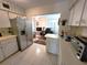 Open kitchen featuring stainless steel refrigerator, white cabinets and view to study at 2311 Brisbane St # 29, Clearwater, FL 33763