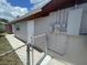 Rear view of the house with door access and the electrical box in the backyard at 6019 W Fern St, Tampa, FL 33634