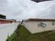 A side view of the house with privacy fence, a grassy area, and an air conditioner at 6019 W Fern St, Tampa, FL 33634