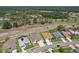 Community aerial view with single Gathering homes, manicured lawns, mature landscaping, and a pond at 6335 Cardinal Crest Dr, New Port Richey, FL 34655