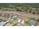 Wide aerial showing homes with manicured lawns in a community near a pond and naturalized area at 6335 Cardinal Crest Dr, New Port Richey, FL 34655