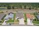 Aerial view showcasing a well-maintained home, lush landscaping, and a private screened-in pool at 6335 Cardinal Crest Dr, New Port Richey, FL 34655