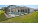 View of the backyard showcasing the screen-enclosed pool and spa, as well as access doors to the house at 6335 Cardinal Crest Dr, New Port Richey, FL 34655