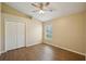 This bedroom has ample closet space, wood-look floors, and a ceiling fan at 6335 Cardinal Crest Dr, New Port Richey, FL 34655