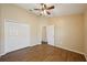 Bedroom featuring wood floors, ceiling fan, and double door closet at 6335 Cardinal Crest Dr, New Port Richey, FL 34655
