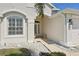 Home's welcoming entryway with a decorated glass door, side bench, and manicured landscaping at 6335 Cardinal Crest Dr, New Port Richey, FL 34655