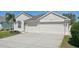 Charming home featuring a three car garage, well manicured lawn, and an inviting front entrance at 6335 Cardinal Crest Dr, New Port Richey, FL 34655
