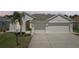 Charming home featuring a three car garage, well manicured lawn, and an inviting front entrance at 6335 Cardinal Crest Dr, New Port Richey, FL 34655