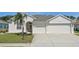 Charming home featuring a three car garage, well manicured lawn, and an inviting front entrance at 6335 Cardinal Crest Dr, New Port Richey, FL 34655