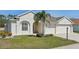 Charming home featuring a three car garage, well manicured lawn, and an inviting front entrance at 6335 Cardinal Crest Dr, New Port Richey, FL 34655
