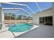 An in-ground pool is surrounded by a screened-in enclosure for leisure at 6335 Cardinal Crest Dr, New Port Richey, FL 34655