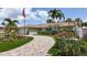 Inviting home with a brick driveway, landscaped yard, and mature palms offering curb appeal at 1120 81St S St, St Petersburg, FL 33707