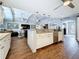 Open-concept kitchen with a large breakfast bar, stainless steel appliances, and wood flooring at 1120 81St S St, St Petersburg, FL 33707