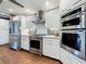 Kitchen with stainless steel appliances, white cabinetry, and a modern backsplash at 1120 81St S St, St Petersburg, FL 33707