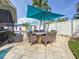 Outdoor patio with dining area, offering a view of the pool, tropical landscape, and white privacy fence at 1120 81St S St, St Petersburg, FL 33707