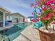 Backyard pool and patio with chairs, umbrella, flowers, and steps leading into the pool at 1120 81St S St, St Petersburg, FL 33707