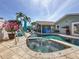 Outdoor spa flows into a spacious pool, set amidst lush landscaping and comfortable seating at 1120 81St S St, St Petersburg, FL 33707