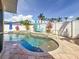 Beautiful backyard pool with turquoise water, tropical landscaping, and a white privacy fence at 1120 81St S St, St Petersburg, FL 33707