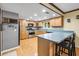 Bright kitchen featuring stainless steel appliances, light wood cabinets, and a breakfast bar at 2204 Krista Ln, Brandon, FL 33511