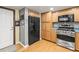 Spacious kitchen featuring stainless appliances, wood cabinetry, a refrigerator, and hardwood floors at 2204 Krista Ln, Brandon, FL 33511