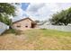 Extensive backyard with green lawn, white fence, and the rear view of the tan home at 18941 Twinberry Dr, Tampa, FL 33647