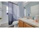 Bathroom features a vanity, toilet, bathtub and shower with a patterned shower curtain at 18941 Twinberry Dr, Tampa, FL 33647