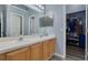 Bathroom featuring double sinks, light countertops, and walk in closet at 18941 Twinberry Dr, Tampa, FL 33647