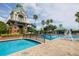 Community pool featuring a water slide and pool bridge amidst lush landscaping and sunny skies at 18941 Twinberry Dr, Tampa, FL 33647