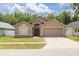 Tan single-story home with a two-car garage and well-manicured front lawn in a quiet suburban neighborhood at 18941 Twinberry Dr, Tampa, FL 33647