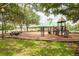 Community playground with mature trees, varied equipment, and safe wood chip ground cover at 18941 Twinberry Dr, Tampa, FL 33647