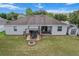 Aerial view of the backyard featuring a fire pit, patio with grill, and ample green space at 13365 Chesapeake Pl, Spring Hill, FL 34609