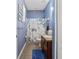 Cozy bathroom with blue walls, decorative shower curtain, vanity, and a soft blue rug at 13365 Chesapeake Pl, Spring Hill, FL 34609