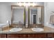 Bathroom with double sinks, granite countertops, and decorative accents under elegant mirrors at 13365 Chesapeake Pl, Spring Hill, FL 34609