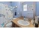 A well-lit blue bathroom with a shower/tub combo, and granite countertops at 13365 Chesapeake Pl, Spring Hill, FL 34609