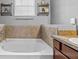 Bathroom bathtub with stone tile and vanity at 13365 Chesapeake Pl, Spring Hill, FL 34609