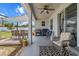 Covered patio area with ceiling fan, sliding door to the home, grill and backyard views at 13365 Chesapeake Pl, Spring Hill, FL 34609