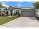Charming home featuring a well-manicured lawn, two-car garage, and stylish gray exterior at 13365 Chesapeake Pl, Spring Hill, FL 34609