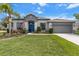 Attractive home featuring a well-manicured lawn, two-car garage, and stylish blue front door at 13365 Chesapeake Pl, Spring Hill, FL 34609