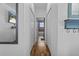 Hallway with wood floors leads to a bathroom with a tub and blue accents at 13365 Chesapeake Pl, Spring Hill, FL 34609