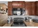 Close up on a kitchen featuring stainless steel appliances, granite countertops, and dark wood cabinetry at 13365 Chesapeake Pl, Spring Hill, FL 34609