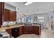 A bright kitchen with granite countertops and island for extra seating overlooks the dining and living areas at 13365 Chesapeake Pl, Spring Hill, FL 34609