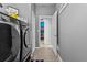 Bright laundry room featuring modern washer and dryer, tiled floors, and gray walls at 13365 Chesapeake Pl, Spring Hill, FL 34609