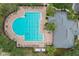 Overhead community pool view featuring lounge chairs, lane lines, sunbathers, and community building in background at 13365 Chesapeake Pl, Spring Hill, FL 34609