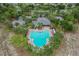 Aerial view of a large community pool surrounded by trees and chairs with a nearby parking lot at 13365 Chesapeake Pl, Spring Hill, FL 34609