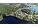 Scenic aerial view featuring a lakeside property with tree coverage and neighboring homes creating a peaceful community at 18101 Boy Scout Rd, Odessa, FL 33556