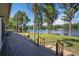 View of the backyard with a deck, lawn, and lake views creating a serene retreat at 18101 Boy Scout Rd, Odessa, FL 33556