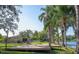 Spacious backyard with a wooden deck, palm trees, and waterfront views at 18101 Boy Scout Rd, Odessa, FL 33556