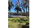Lakeside backyard with an outdoor deck, surrounded by mature trees at 18101 Boy Scout Rd, Odessa, FL 33556