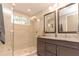 Luxurious bathroom with a glass shower, granite countertops, and dual mirrors create a spa-like retreat at 18101 Boy Scout Rd, Odessa, FL 33556